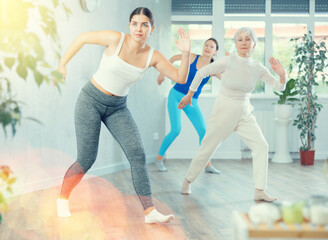 Obraz premium Young sports woman engaged in dancing in fitness studio