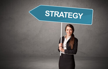 Young business person in casual holding road sign