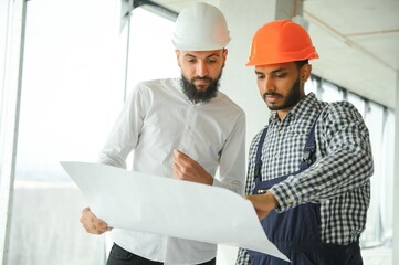 Young attractive arabic industrial engineer in hard hat. Professional and industry, builder architect job, worker checking work at plant indoor