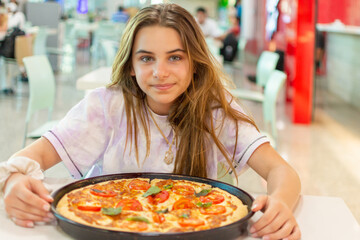 Adolescente menina com pizza inteira para degustar