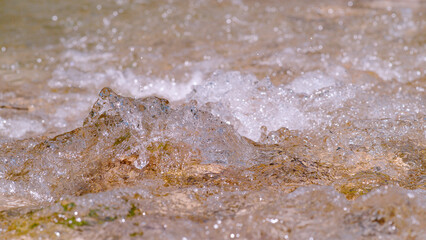 CLOSE UP, DOF: Splashing and sparkling bubbly water surface of mountain river