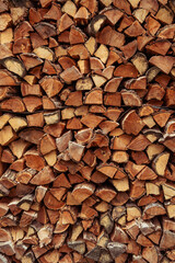 Background of stacked chopped wood logs. Pile of wood logs ready for winter. Wooden stumps, firewood stacked in heap