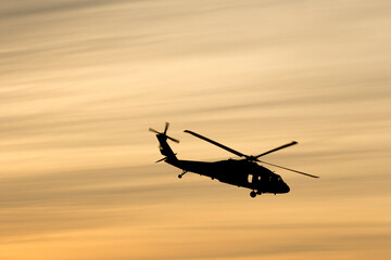 Black hawk helicopter silhouette with cloud streaks