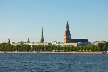 Fototapeta premium Riga. in the photo, the panorama of the city of Riga, the river in the foreground, the blue sky in the background