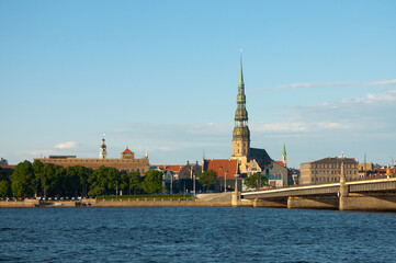 Obraz premium Riga. in the photo, the panorama of the city of Riga, the river in the foreground, the blue sky in the background