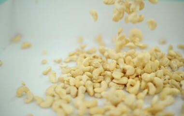 Pouring raw cashews on white background. video was shoot using custom light set up with additional custom build underneath light system to eliminate shadows Close up of cashew nuts pattern texture