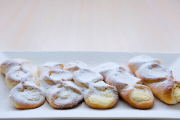 homemade cakes pies with cottage cheese sprinkled with powdered sugar on a white round plate Bright table grandmother's pies for children grandchildren are made with love