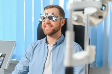Adult man eyesight test with binocular slit-lamp. Checking retina of a male eye close-up. Ophthalmology Clinic - obrazy, fototapety, plakaty