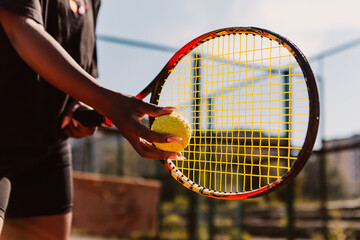 African american woman hold racket and yellow green ball, playing tennis match on clay court surface on weekend free time sunny day. Female player ready to serve. Professional sport concept
 - obrazy, fototapety, plakaty