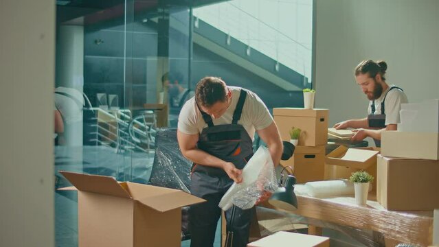 Workers of Moving Company With Uniforms Carefully Packing and Carrying Boxes. Shipping and Packaging Business Occupation Service Company. Preparation for a Long Trip, Transportation of Things