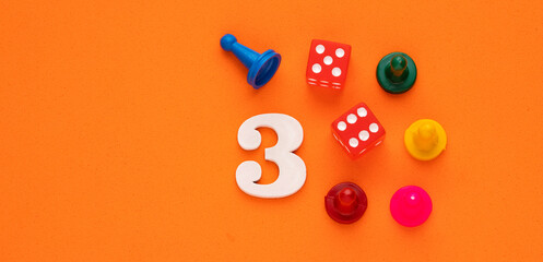 Number three in white with pieces and gambling dice - Orange eva rubber background