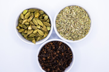 Fennel seeds, Cardamom, and Cloves in bowls