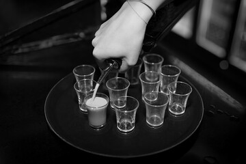 the bartender pours into the glasses 