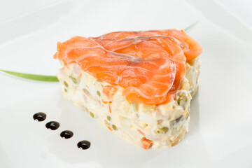 salad with salmon on a white plate in the shape of a heart