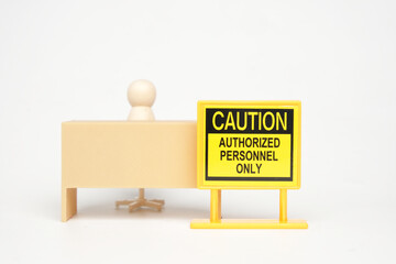 A picture of caution authorized personnel only sign with office desk miniature and peg dolls insight.