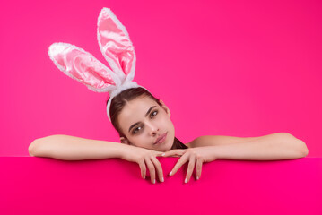 Obraz na płótnie Canvas Easter woman. Cheerful young girl celebrating easter isolated over studio background. Studio photo of a young woman wearing bunny ears. Festive bunny.