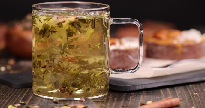 round cake stuffed with salted caramel with nuts and a mug of hot green tea