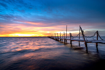 Fototapeta na wymiar Wooden bridge on the beach at dawn in Phu Quoc island, Vietnam. Long exposure time