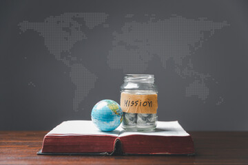 Savings jars full of money and globe with Holy Bible for mission, Mission christian idea. bible and...