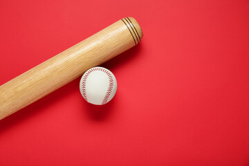 Wooden baseball bat and ball on red background, flat lay. Space for text
