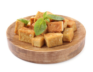Wooden plate with delicious fried tofu, basil and sesame seeds isolated on white