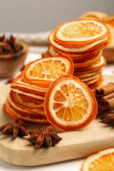 Dry orange slices, anise stars and cinnamon sticks on wooden board, closeup