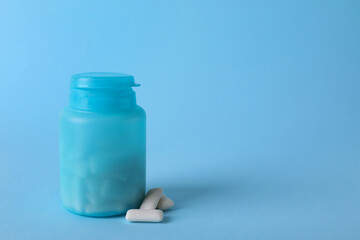 Jar with chewing gums on light blue background. Space for text