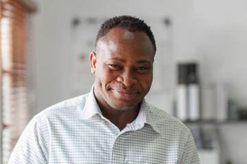 Smiling confident African American businessman at office. Strategy, chart, finance report concept