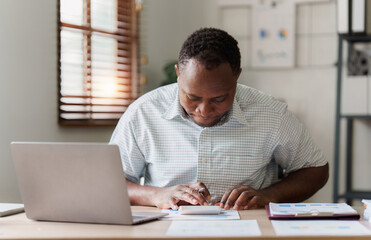 American African Businessman research and analysis with financial graph at office. Strategy, chart,...