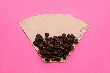 Paper coffee filter and beans on pink background, top view