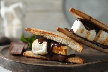 Delicious marshmallow sandwiches with chocolate on wooden tray, closeup