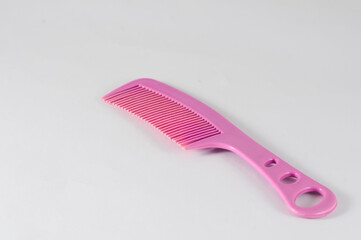 pink plastic hair comb isolated on a white background