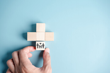 Health and Life insurance of protect family concept. hands holding plus and healthcare medical icon on wooden cube block, health and access to welfare health concept...