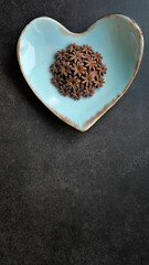 Chocolate flavor, Brown color, Sam Pan Nee traditional Thai handcraft snack on pastel blue heart shape plate, Dark background, vertical image with copy space