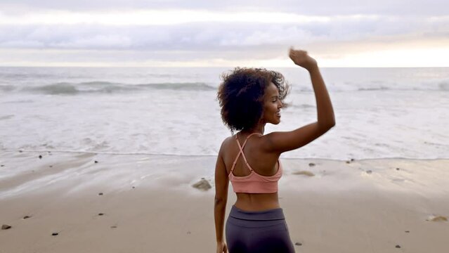 Athletic Somali woman dancing on the beach in Malibu California. Slow motion.