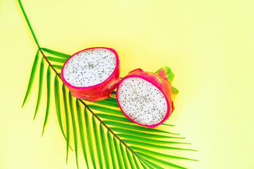 Fresh half dragon fruit or pitahaya (pitaya) with leaf on yellow background, top view