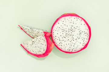 Slices of delicious pitahaya fruit on green background
