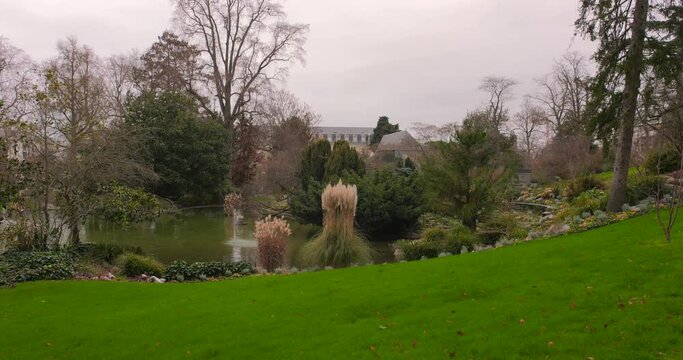 Jardin des plantes d'Angers Park With Green Lawn And Pond In Angers, France - wide