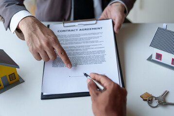 Real estate agent and a client are negotiating a home purchase agreement and deliver the key.