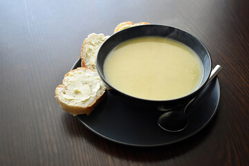 Leek and potato soup with bread and margarine on the table. 