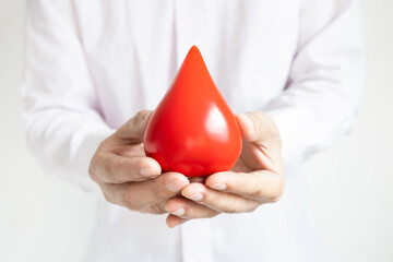 healthy man's hand holding blood symbol Blood Donation Help and Health Concepts.