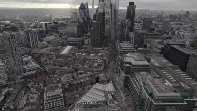 Town on cloudy day. Tilt up reveal of group of modern downtown skyscrapers in City business borough. London, UK