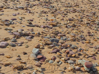 Pebbles on the beach. Very strong sunshine on the small rock beach background. Peace and calm vacation concept.