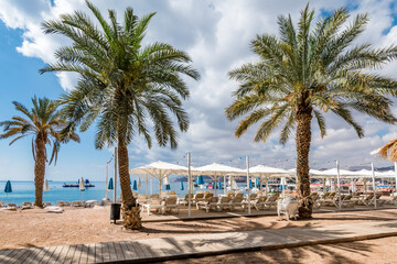 Obraz na płótnie Canvas Morning on central public beach of the Red Sea in Eilat - famous tourist resort and recreational city in Israel. Concept of bliss vacation and happy holiday 