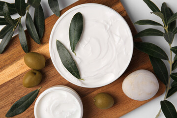 Fototapeta na wymiar Flat lay composition with jars of cream and olives on white background