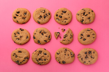 Many delicious chocolate chip cookies on pink background, flat lay