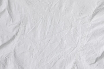 Naklejka na ściany i meble Crumpled white fabric as background, top view