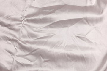 Crumpled light pink fabric as background, top view