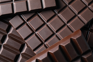 Many delicious dark chocolate bars as background, top view