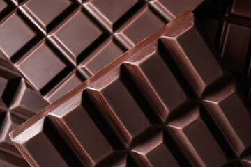 Many delicious dark chocolate bars as background, top view